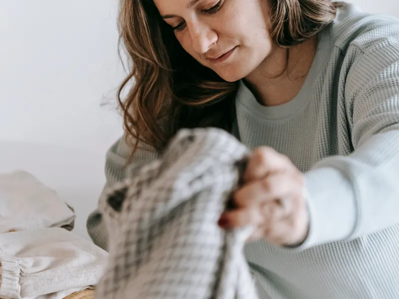Woman folding freshly washed clothes at a table